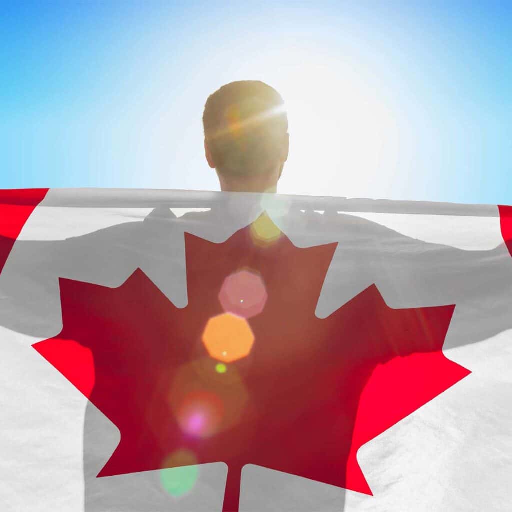 Man with Canadian flag across their back.